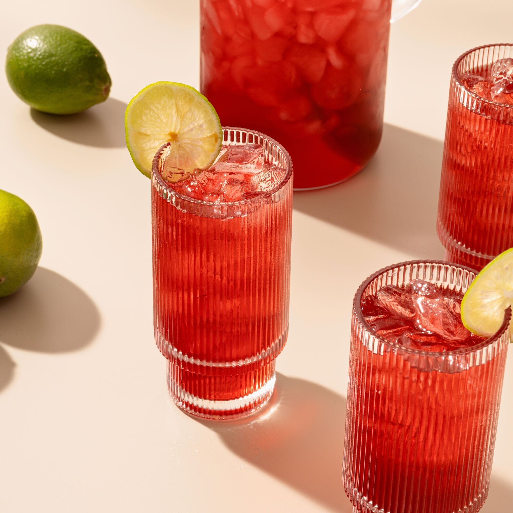 A pitcher of Hibiscus Berry sangria with limes and lime wedges from Rishi Tea & Botanicals.