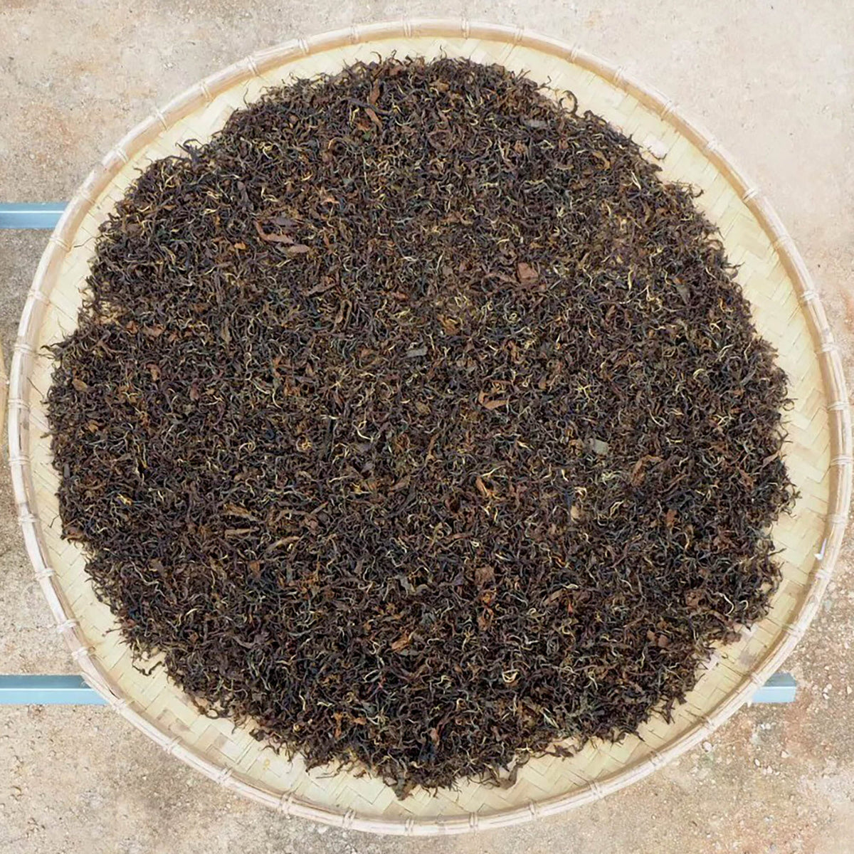 A bowl of Doi Wawee Sun-Dried Red Tea from Rishi Tea & Botanicals sitting on top of a table.