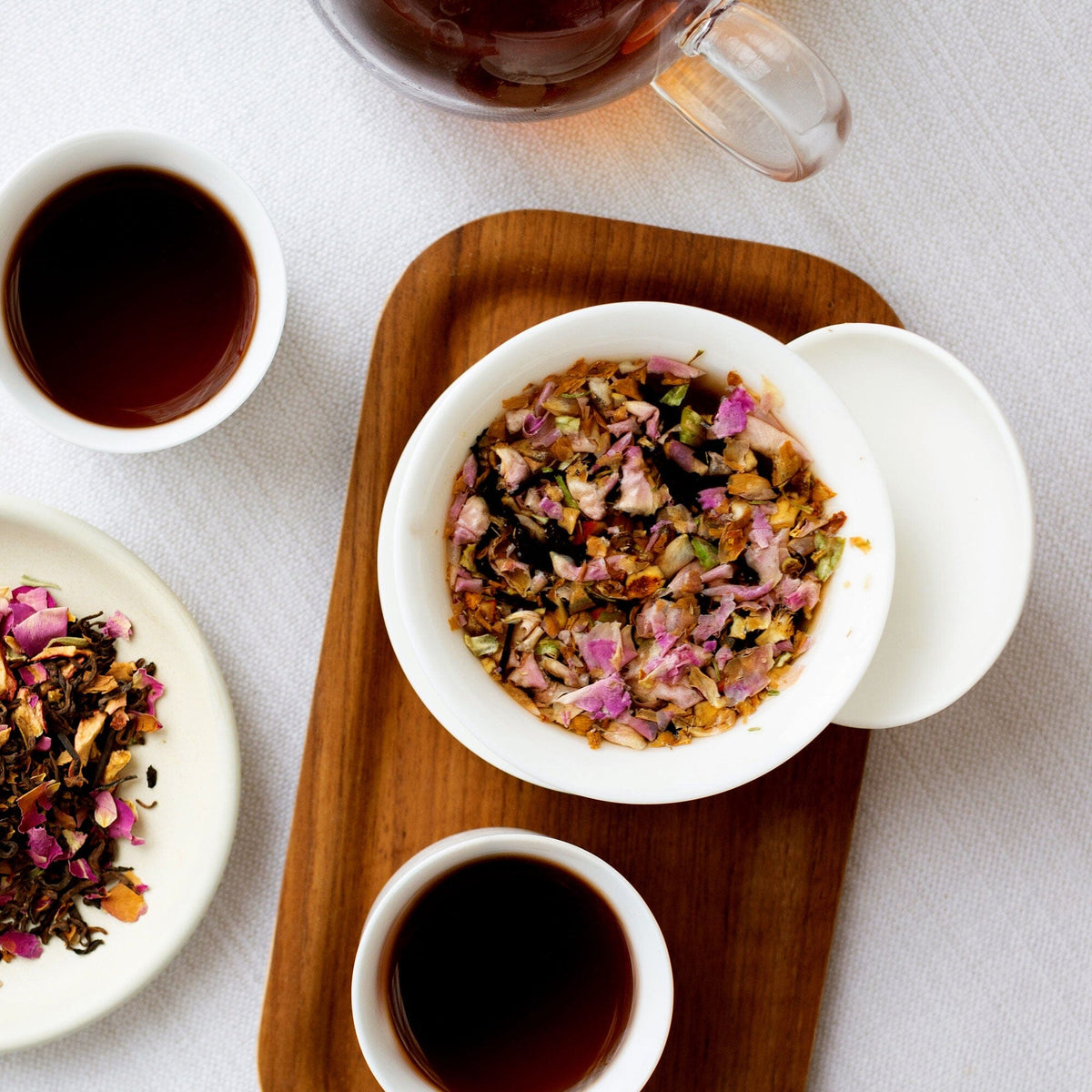 Two bowls of Rishi Tea & Botanicals' premium oolong and pu'er teas and a cup of coffee on a tray, served in a Gaiwan Teapot.