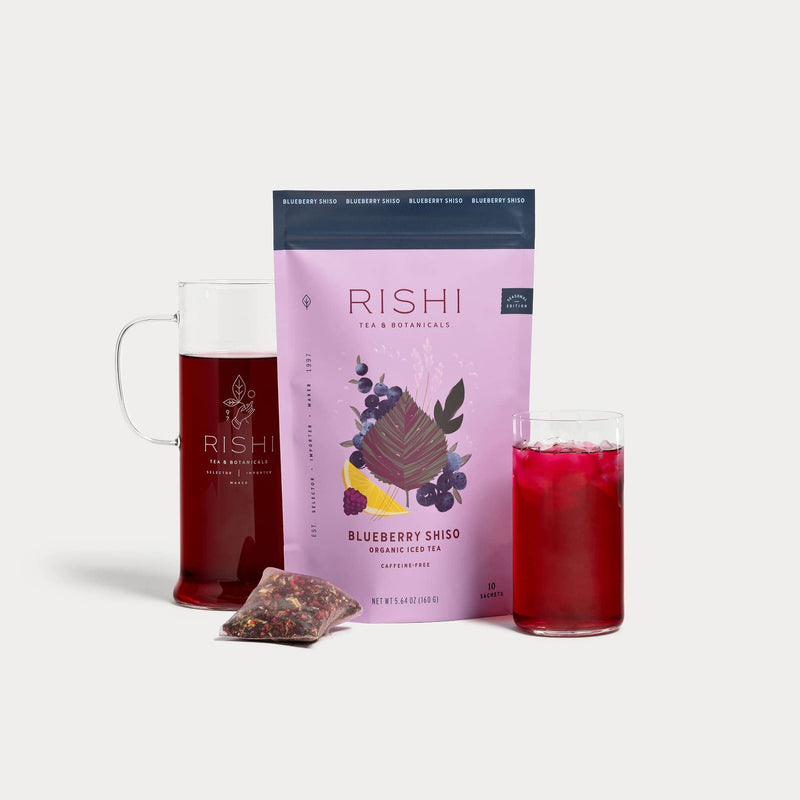 Rishi Blueberry Shiso Iced Tea package with a glass of tea and Simple Brew on a white background