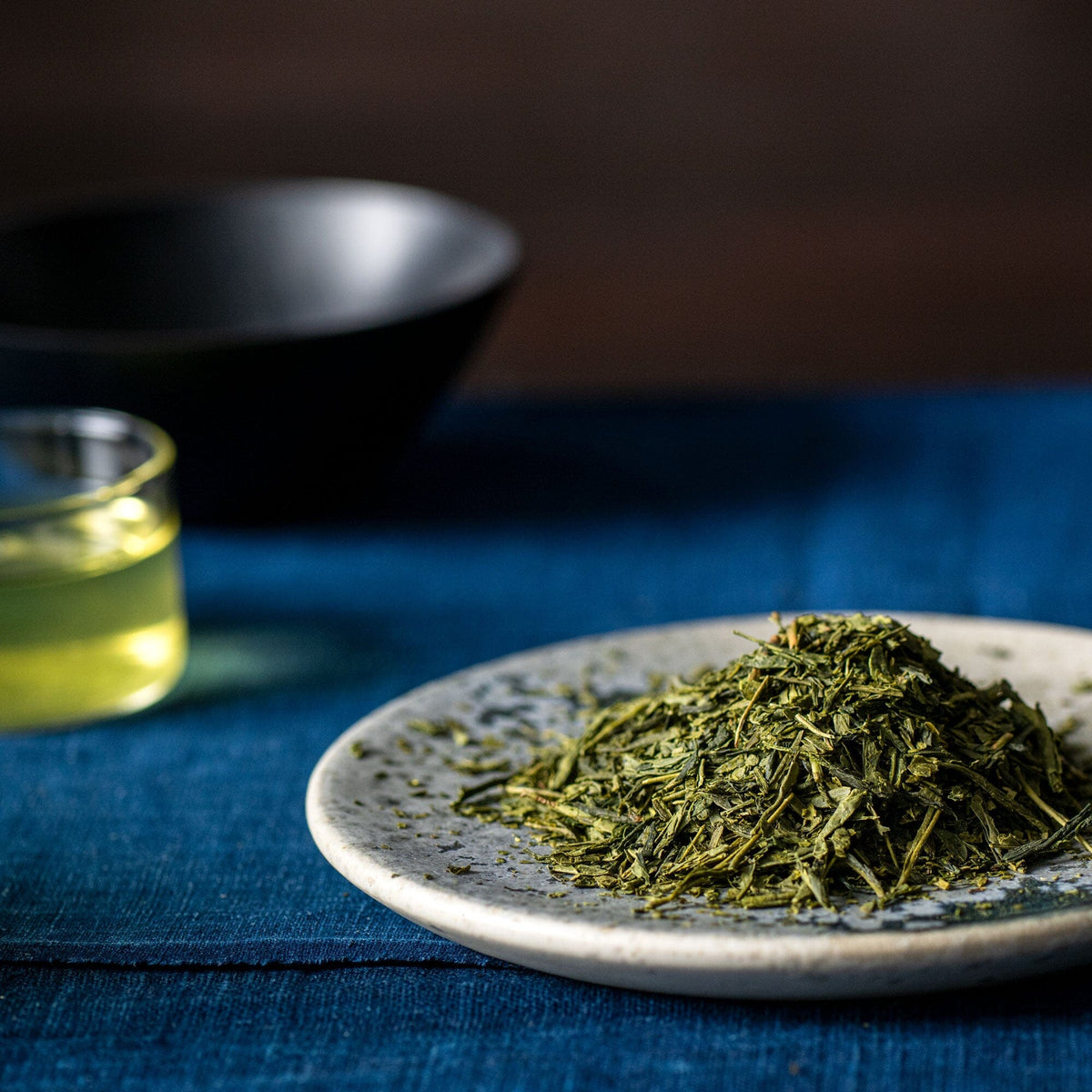 Japanese Bancha green tea on a plate with a glass of water from Rishi Tea & Botanicals.