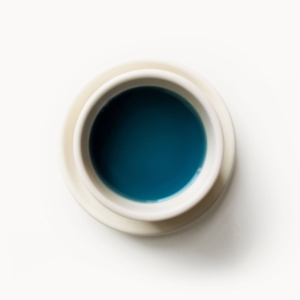 A cup of Butterfly Pea Flower by Rishi Tea & Botanicals on a white background.