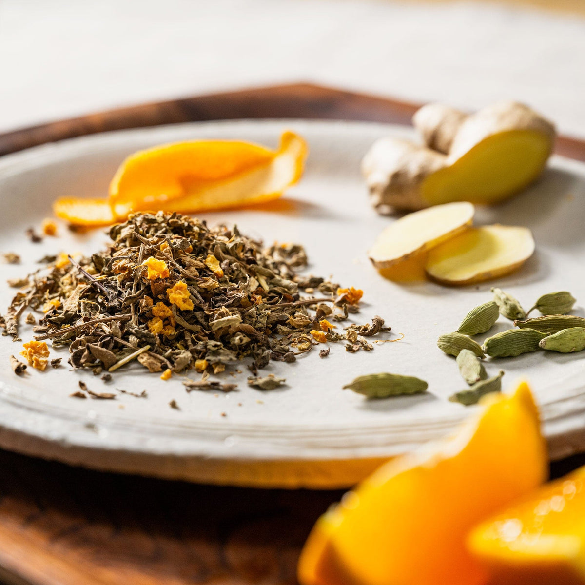 A plate with Cinnamon Tulsi Spice from Rishi Tea & Botanicals, oranges, ginger, and spices on it.