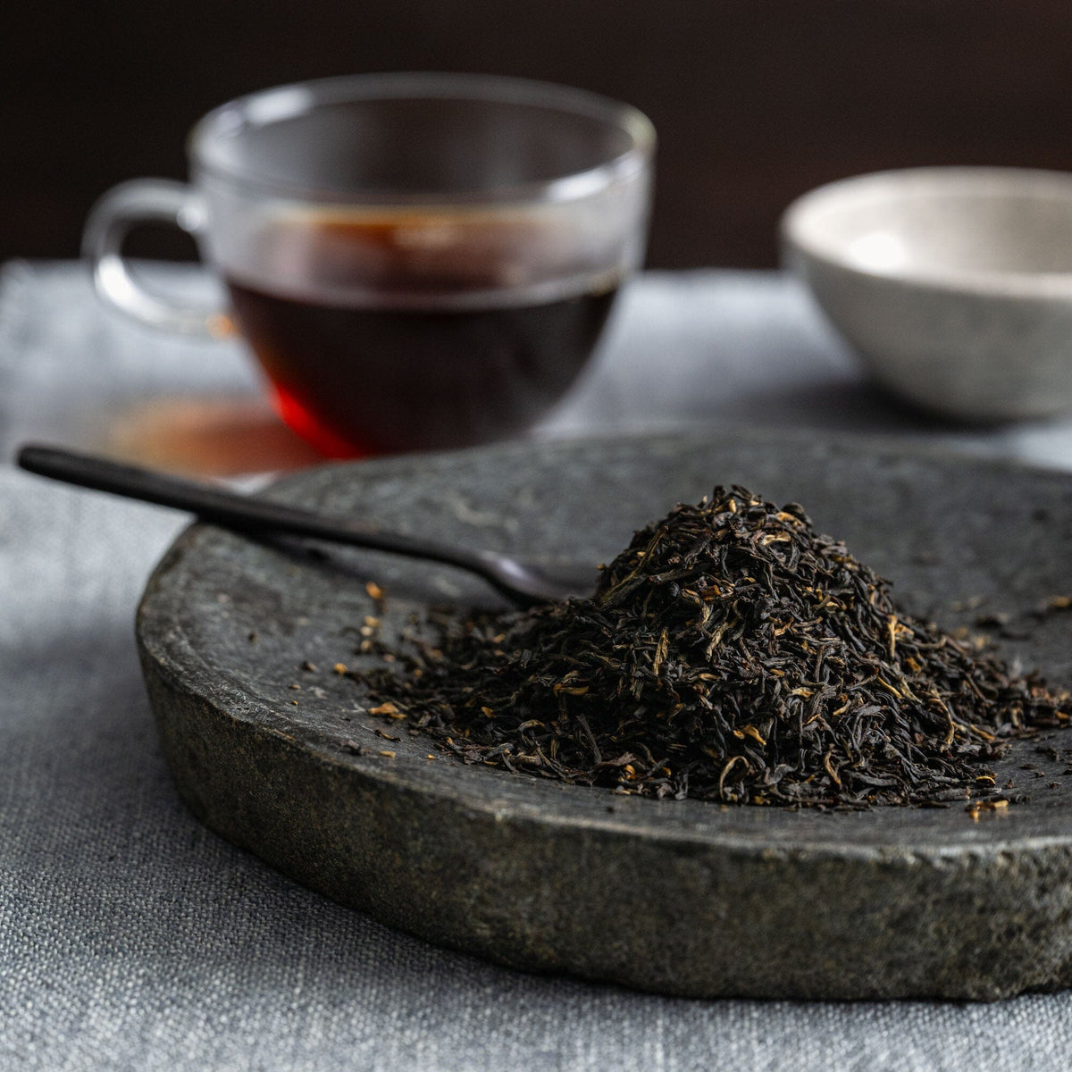 Earl Grey Supreme by Rishi Tea & Botanicals on a stone plate with a cup of tea.