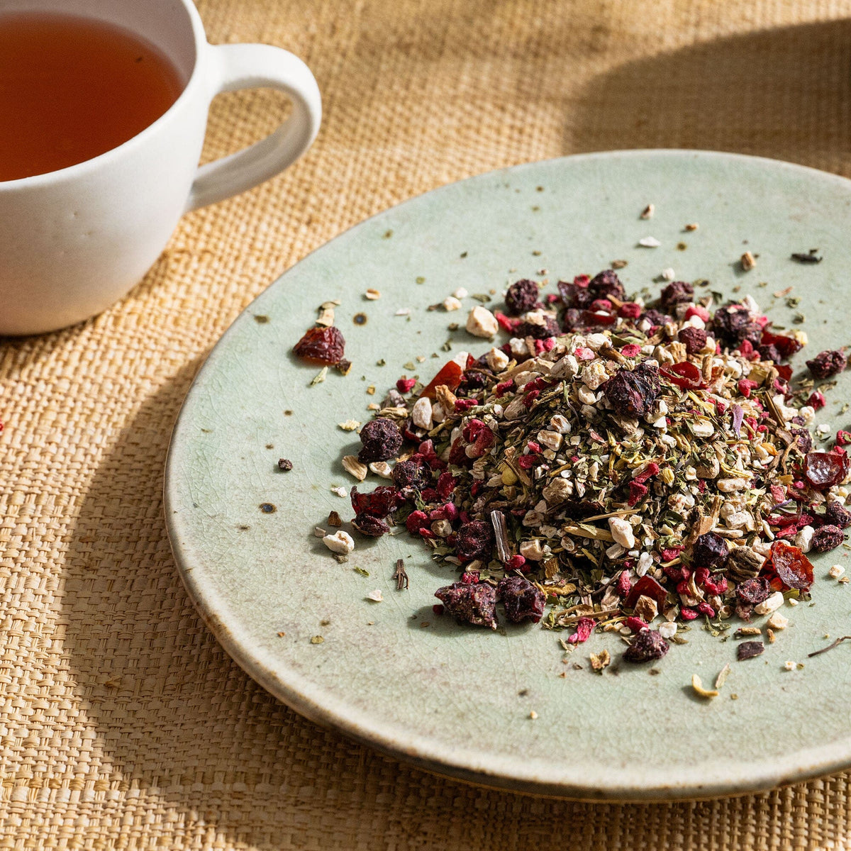 A green Ginseng Detox plate with a cup of Rishi Tea & Botanicals on it.