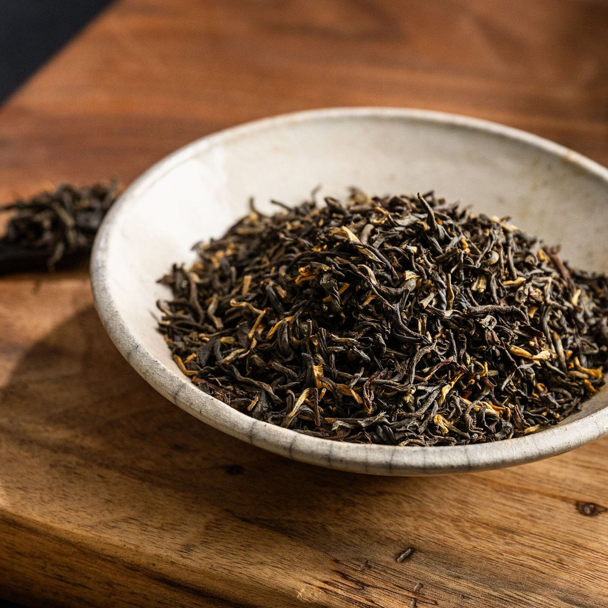 A bowl of Golden Yunnan tea from Rishi Tea & Botanicals on a wooden table.