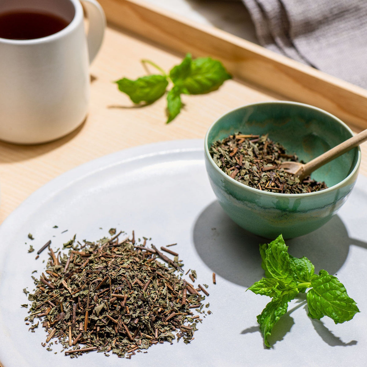A bowl of Green Tea Mint with a cup of Rishi Tea & Botanicals tea next to it.