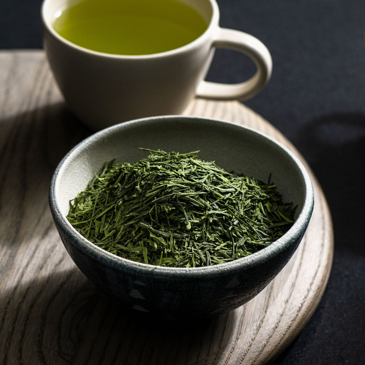 A bowl of Matcha Gyokuro tea sits next to a cup of Rishi Tea & Botanicals.