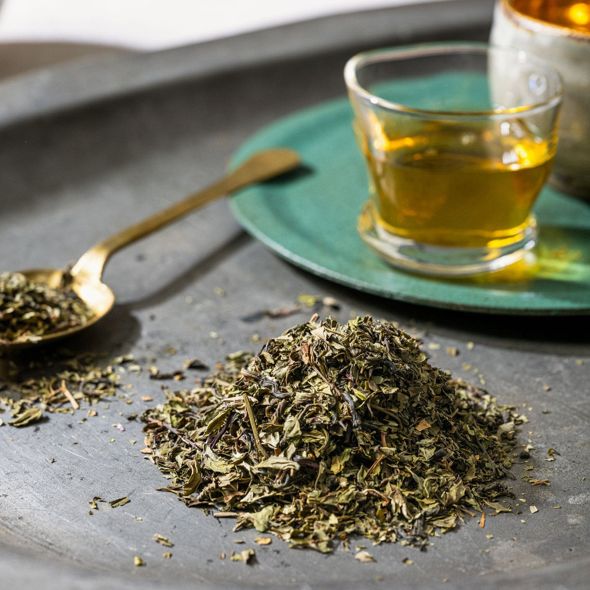A cup of Moroccan Mint tea on a tray with a spoon from Rishi Tea & Botanicals.