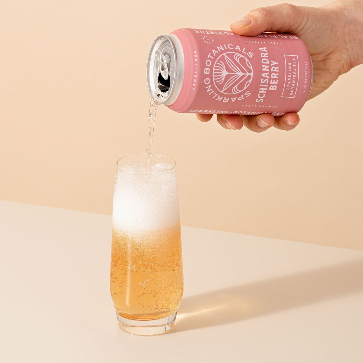 A person pouring a can of Rishi Tea & Botanicals Schisandra Berry into a glass.