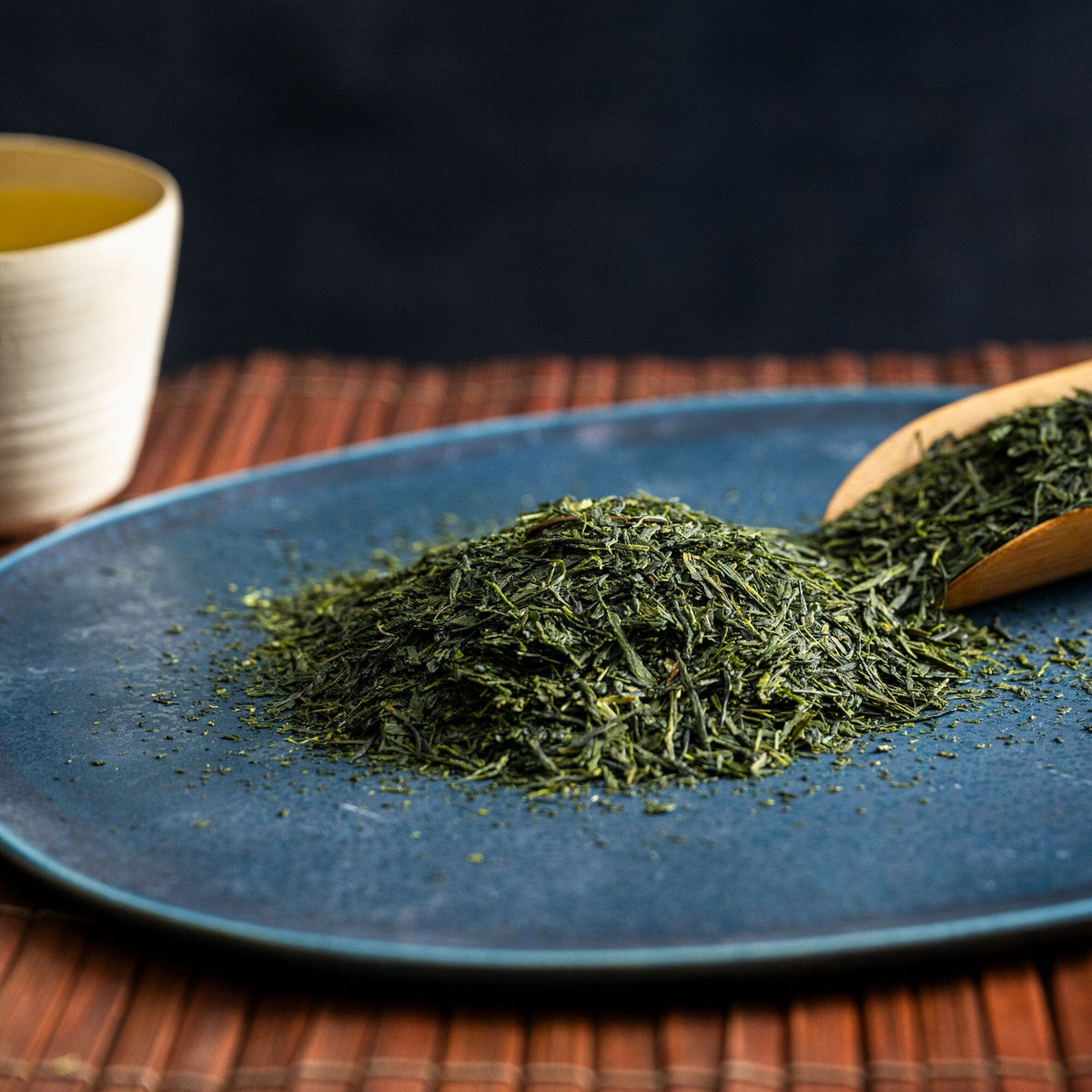 Sencha from Rishi Tea & Botanicals on a blue plate with a wooden spoon.
