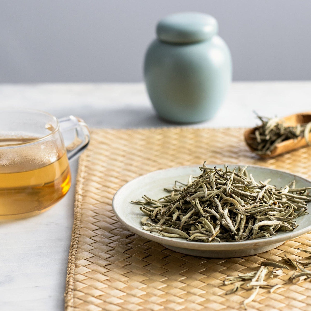 A bowl of Chinese white tea from the China Flight of Tea Bundle by Rishi Tea & Botanicals on a table next to a cup.