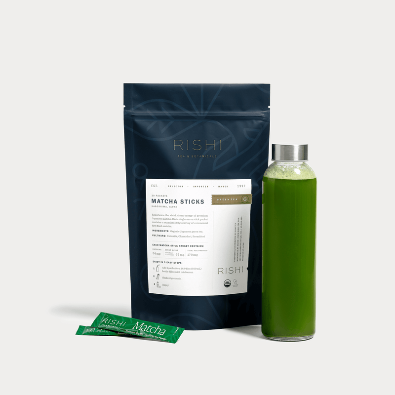 A box of Rishi Tea & Botanicals organic matcha sticks, two single-serve packets, and a clear bottle with green matcha tea are set against a white background—ideal for enjoying high-quality matcha anywhere.