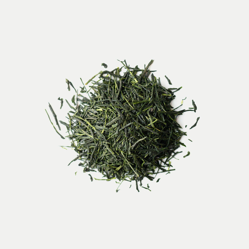 A pile of hand-picked shincha green tea from Rishi Tea & Botanicals, showcasing a micro-lot harvest, rests on a plain white background.