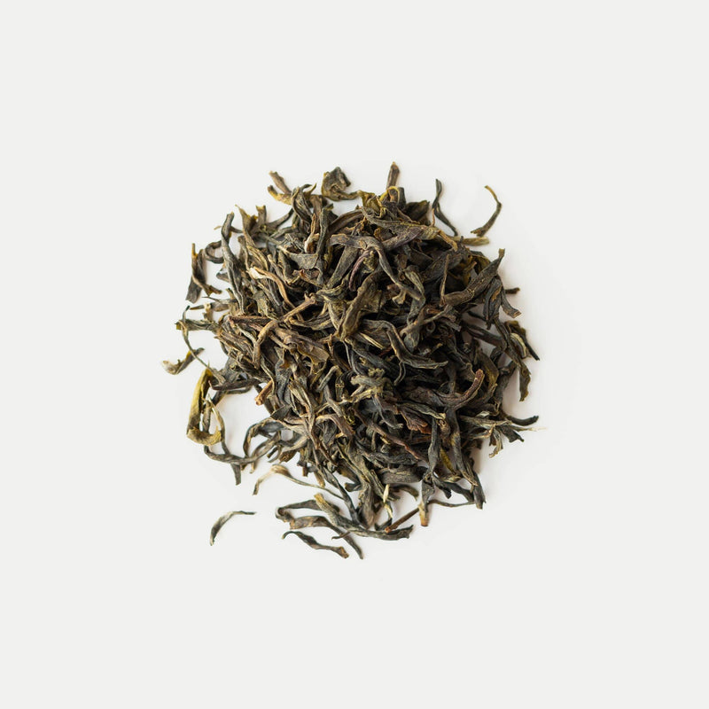 Dry green tea leaves on a white background