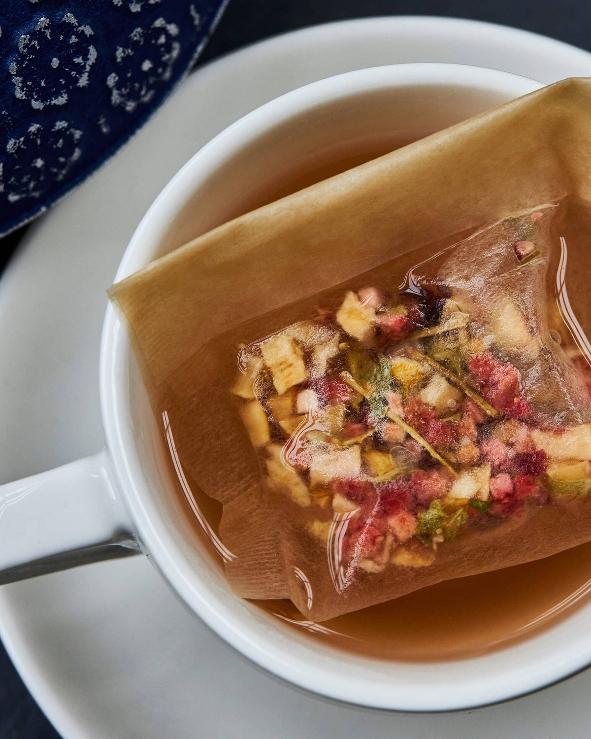 A cup of Riensch & Held, GmbH & Co. loose leaf tea filters with fruit in it.