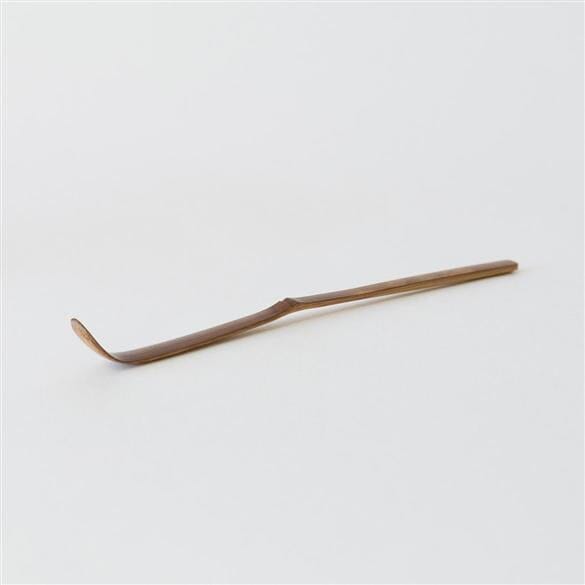 A Chashaku Bamboo Matcha Scoop by Rishi Tea & Botanicals on a white surface.