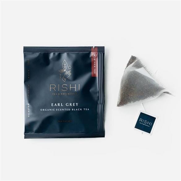 A bag of Rishi Tea & Botanicals Premium Sachet Sampler with a tea bag next to it.